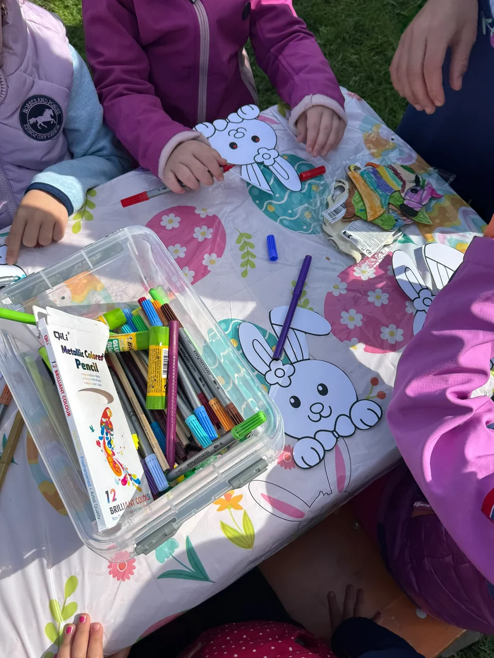 Kinder bemalen und verzieren Tiermasken mit bunten Stiften am Basteltisch.