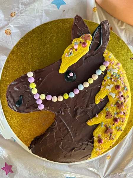 Ein Schokoladenkuchen ist als Pferdekopf mit bunter Verzierung gestaltet.